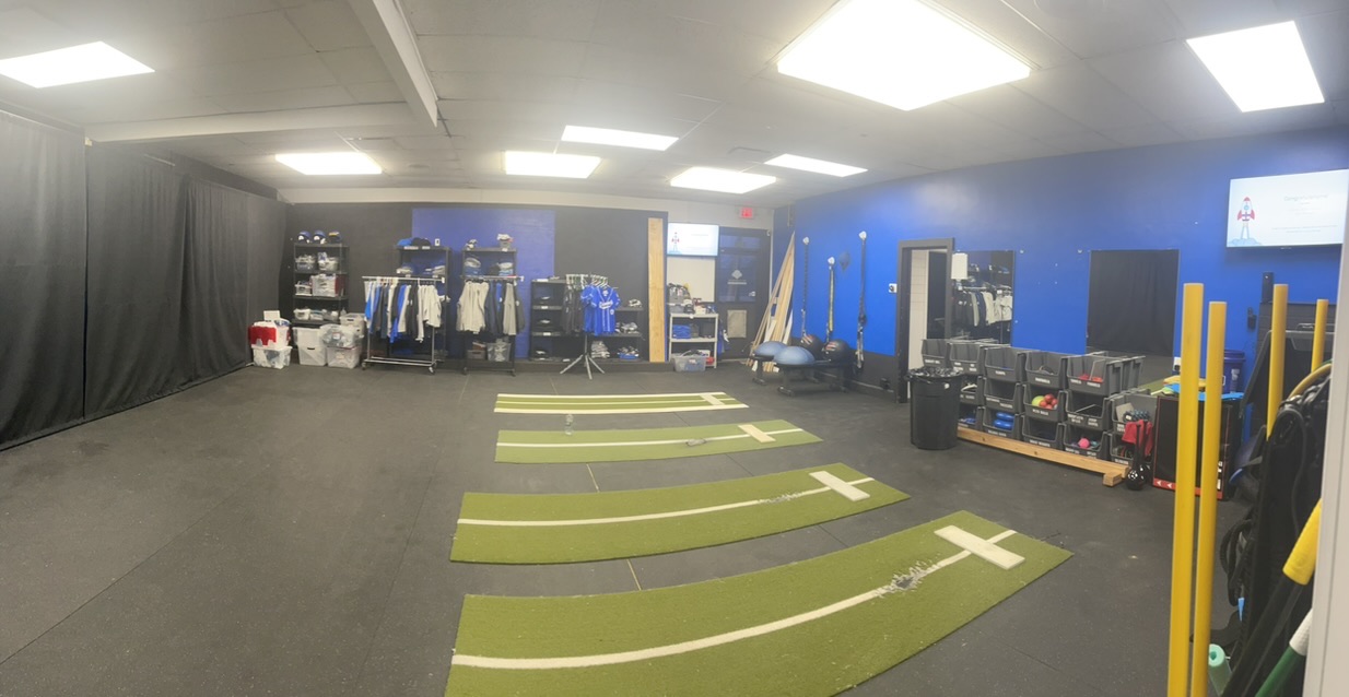 The training room, empty, with pitching lanes laid out on the floor.
