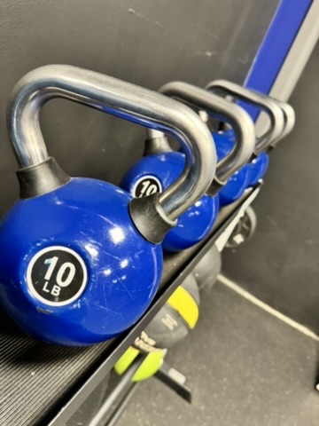 Kettlebells on a rack in the strength area.