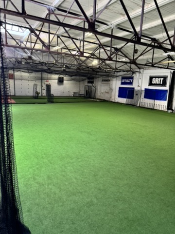 The open turf, empty, with the cage nets retracted.